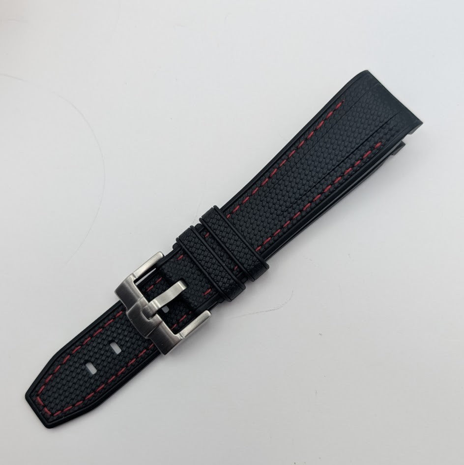 Black watch strap with red stitching on a light gray background