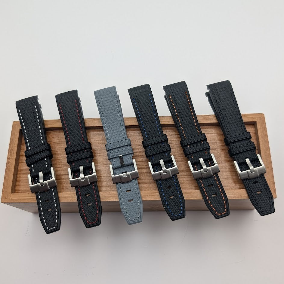 Set of six watch straps on a wooden tray with a light gray background