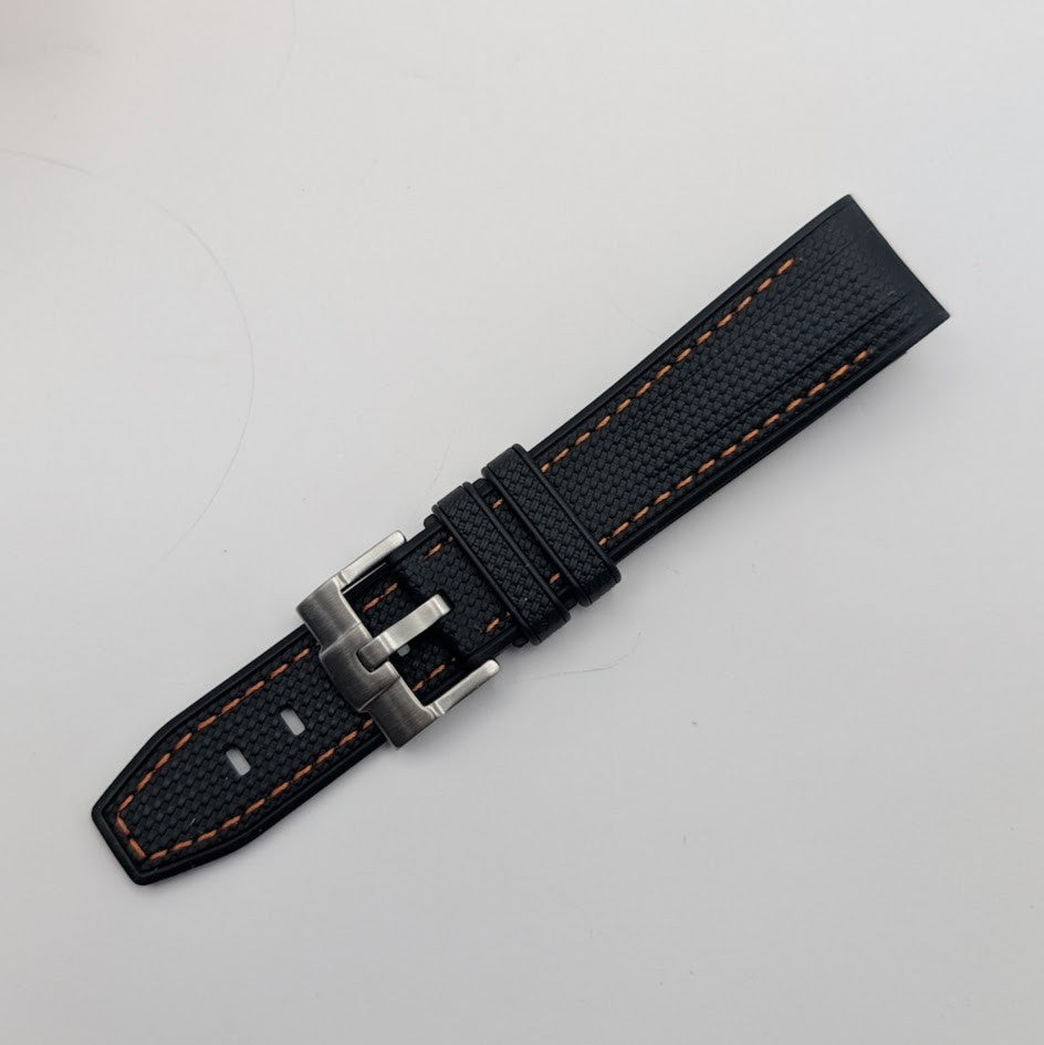 Black watch strap with orange stitching on a light gray background