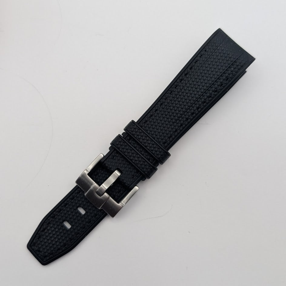 Black watch strap with silver buckle on a light gray background