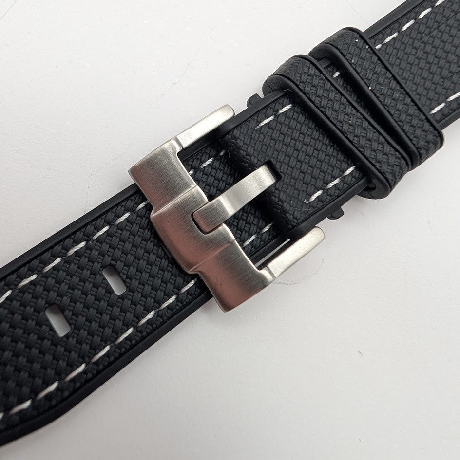 Black watch strap with silver buckle on a light gray background